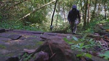 The man walking on the tropical forest for hiking mountain, to the travel destination on Semarang Central Java. The photo is suitable to use for adventure content media, nature poster and forest. video