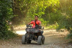 NAKHONNAYOK, THAILAND - DECEMBER 19 Tourists riding ATV to nature adventure on dirt track on DECEMBER 19, 2015, Thailand. photo