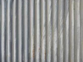 Closeup old and rusty corrugated zinc sheet wall, grunge background metal texture photo