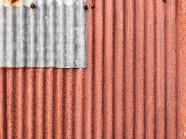 Closeup old and rusty corrugated zinc sheet wall, grunge background metal texture photo