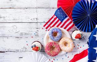 Sweet cupcakes and donuts with usa flag on wooden background photo