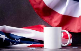 Blank white cup for mockup design over USA flag background photo