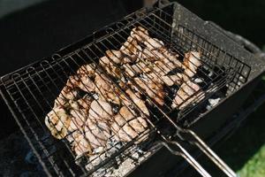 Shish kebab of chicken thighs on the grill on the grill are fried photo