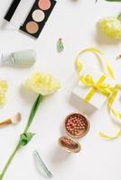 Decorative flat lay composition with cosmetics and flowers. Flat lay, top view on white background photo