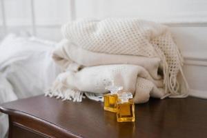 Two glass bottles with perfume or perfume in vintage style on the bedside table photo