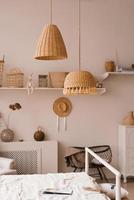 Traditional asian interior bedroom at cozy house with ethnic decor. Wicker lamps above the bed photo