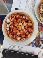 spanish dish galician style octopus with potatoes at restaurant photo