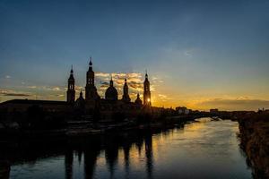 urbano puesta de sol terminado el pilar catedral en zaragoza, España y el ebro río foto