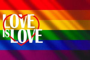 The gay pride rainbow flag with shadows and the words, love is love. Gay pride movement. photo