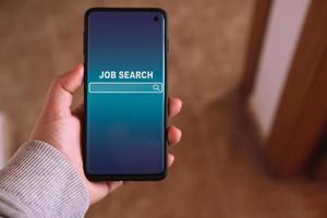 mujer utilizando teléfono inteligente a encontrar un trabajo. encontrar tu carrera profesional. en línea sitio web en pantalla a buscar un trabajo. foto