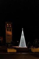 luminoso Navidad árbol decoración en un noche antecedentes de un Español pueblo foto