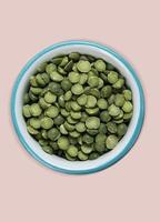 green peas in halves in bowl isolated on background. Top view. Flat lay photo