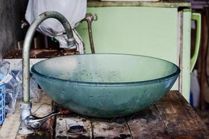 Old washbasin with rust stains on old table. photo