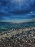 calm blue seaside landscape with water and sky and sailboats photo