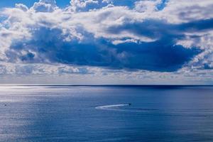 calma azul playa paisaje con agua y cielo y veleros foto