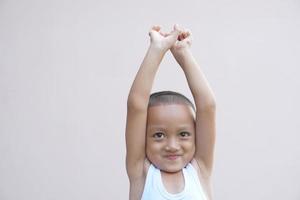 Asian boy smiling happily raise your hand up photo