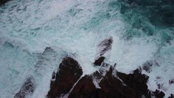 enfurecido água com espumoso ondas em a rochoso costa do caion de praia dentro corunha, Espanha. aéreo Careca video