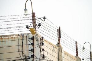 prisión seguridad eléctrico cerca y alto hormigón pared. prisión alto voltaje cerca. mordaz cable seguridad cerca. maquinilla de afeitar cable cárcel cerca. prisión para arrestar criminales o terroristas militar zona concepto. foto