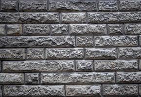 Textural background of an old stone wall made of limestone. Neatly cut gray bricks and good masonry. photo