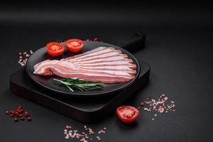 Delicious fresh pancetta with salt and spices cut into thin slices photo