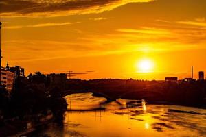 pintoresco puesta de sol en un verano día en el ciudad de zaragoza en España con vista a el río y el catedral foto