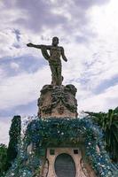 neptune fountain statue in a park in saragossa spain decorated with flowers photo