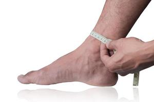 Close-up of a man measuring foot size with a measuring tape on a clipping path white background photo