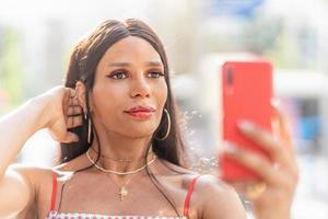 retrato de un Transgénero mujer posando mientras tomando un selfie foto