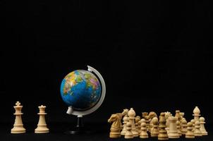 An Earth globe and chess pieces photo