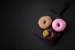 Delicious donut with cream filling and nuts on a dark concrete background photo