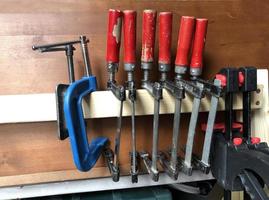 row of hanging screw clamps, a carpentry workshop photo