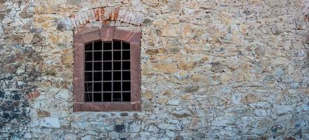 Banner with ancient stone wall and a metal grid window as a prison with copy space background. Concept of freedom and liberty. photo