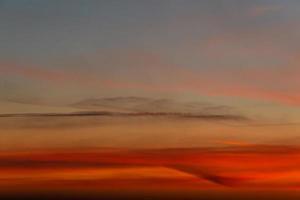 Panoramic view with gradient deep orange sky, illuminated clouds at bloody sunset as a background. photo