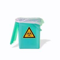 Fluorescent garbage trash bin with its shadows and radiation danger orange symbol isolated at white background. Concept of nuclear waste recycling and environment. photo