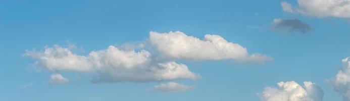 Banner with panoramic view over deep blue clean sky with illuminated clouds as a background. photo