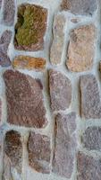 Panoramic view over a long middle age stone wall with patterns of ancient bricks and stones as a background, closeup, details. photo