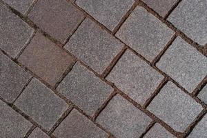 Pattern of ancient bricks and stones at old middle age pavement, as a background, closeup, details. photo