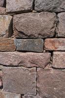 Pattern of ancient bricks and stones at old middle age fortress wall, as a background, closeup, details. photo