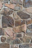Pattern of ancient bricks and stones at old middle age wall, as a background, closeup, details. photo