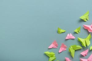 Paper butterfies green and pink colors flat lay on a colored background. Copy space. Lightness, spring beauty concept photo