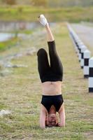 joven niña haciendo yoga aptitud ejercicio Mañana amanecer al aire libre en el prado hermosa montañas paisaje. meditación y relajarse. foto