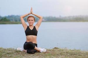 joven niña haciendo yoga aptitud ejercicio Mañana amanecer al aire libre en el prado hermosa montañas paisaje. meditación y relajarse. foto