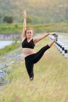 Young girl doing yoga fitness exercise Morning sunrise outdoor in  the meadow beautiful mountains landscape. Meditation and Relax. photo