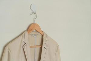 beige suit hanging with wood hanger photo