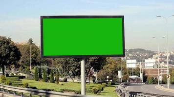 de reclamebord Aan de manier, reclame aanplakbord groen scherm Aan zijlijnen van snelweg met verkeer, lawaai effect, selectief focus video