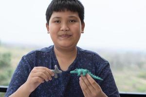 An autistic boy molding different shapes of colored plasticine prepared by parents at home in order to develop various aspects in their son which has slower brain development than normal children. photo