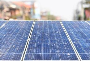 Photovoltaic rooftop panels or solar cell rooftop panels which are so dirty with dust, smoke, rain stain, dried leaves and bird's droppings on upper surface, maintenance to increase quality concept. photo