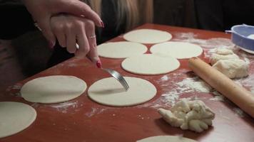 Grandmother teaches her granddaughter to make simple unleavened cakes. She holds her by the hand guiding the movements of the granddaughter. video