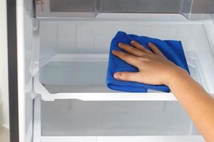 Employees use a cloth to clean the refrigerator. photo