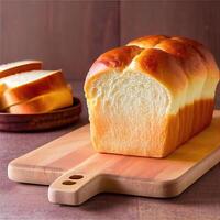 Homemade soft, fluffy white bread loaf, Japanese milk bread. The bread has a brown golden crusty exterior and soft fluffy interior loaf. photo